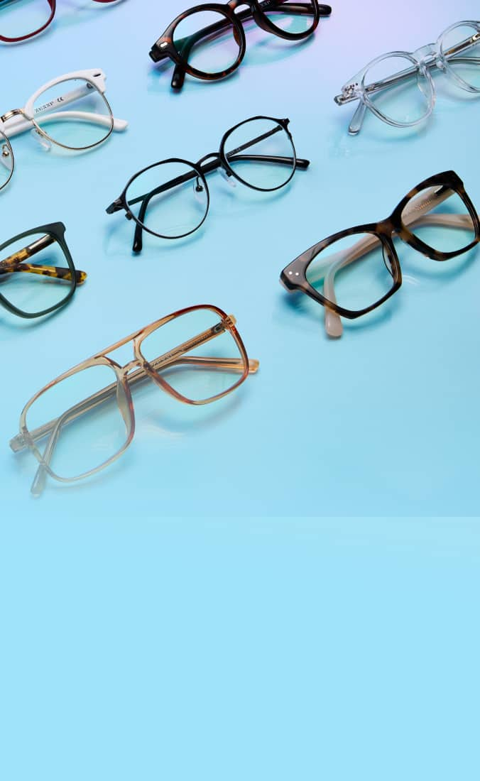 A collection of various eyeglass frames arranged on a smooth, light blue surface.