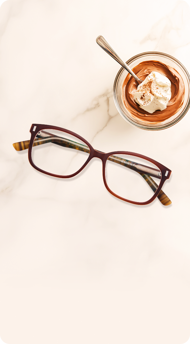 Brown Zenni metal-rimmed glasses with gold accents on a beige background.