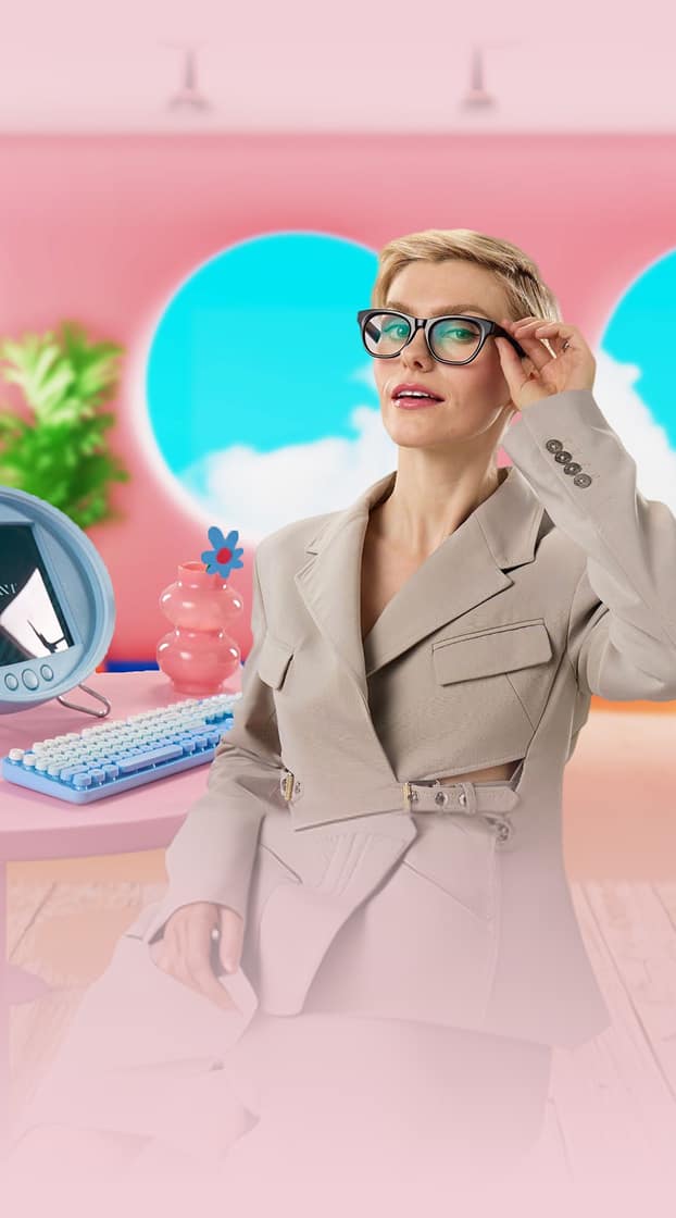 Woman wearing Zenni glasses in a styled indoor setting with digital device highlighting blue light lenses