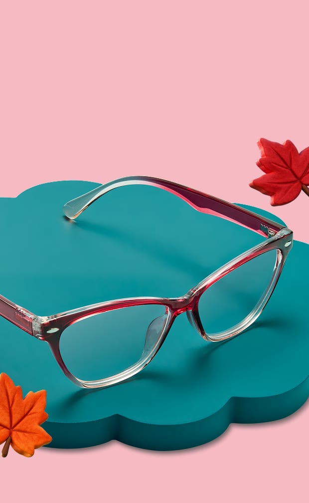 Un style œil-de-chat rouge Zenni présenté sur un support bleu canard avec des feuilles d'automne sur fond rose clair.