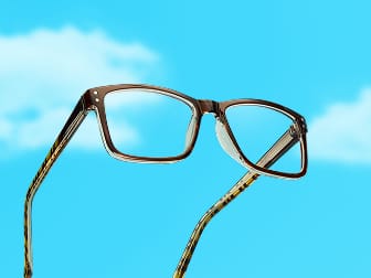 Zenni glasses in translucent brown rectangular frames with clear lenses against a blue sky background