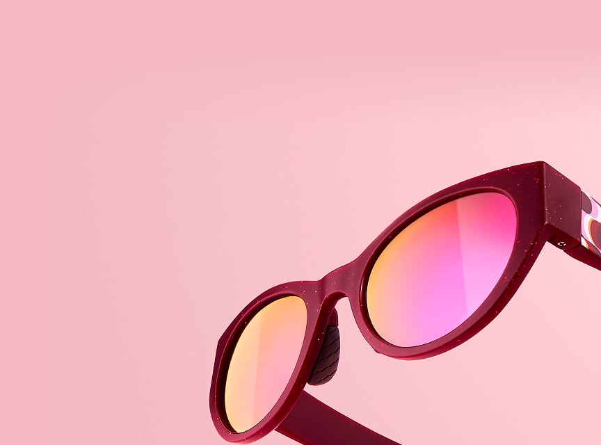 Zenni sunglasses in red frames with pink lenses displayed over a pink background