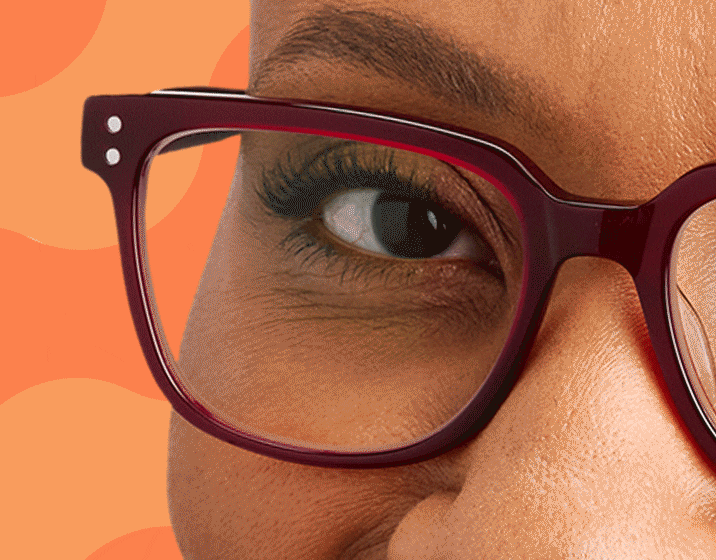 Close up of a woman wearing red square Zenni glasses with Transitions lenses that are clear indoors.
