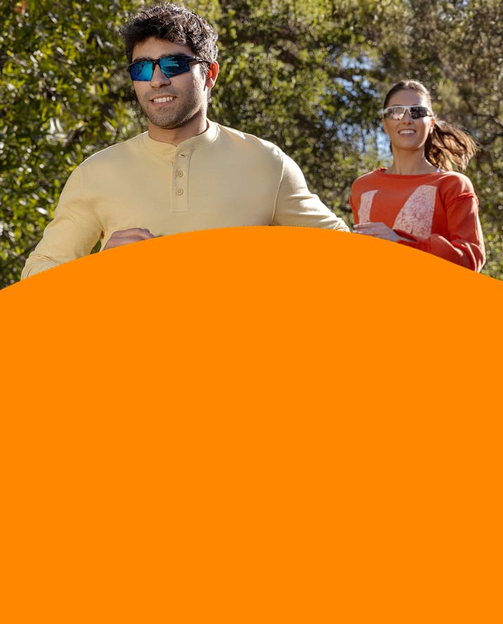 Two people jogging outdoors wearing Zunnies Sports Sunglasses under bright, sunny skies.