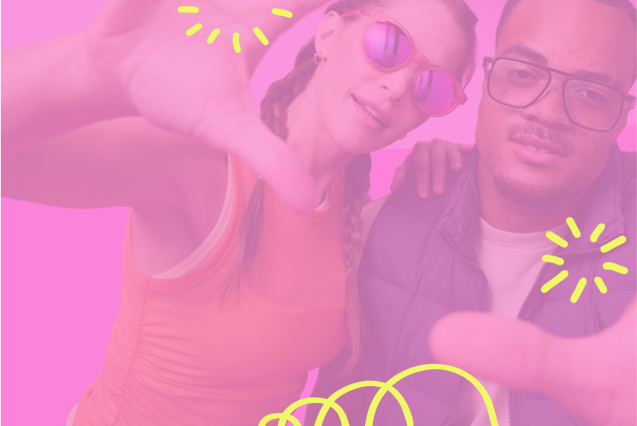 Two people pose playfully against a bright pink backdrop. One wears pink reflective sunglasses and an orange tank top; the other wears black glasses, a white shirt, and a purple vest. Both gesture toward the camera under yellow doodle sparkles.