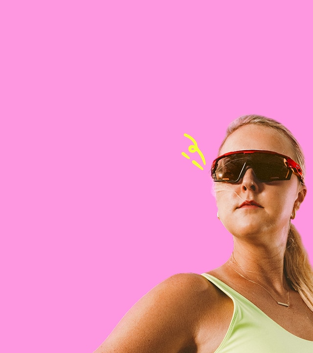 A female athlete in red sports sunglasses and a lime green top gazes ahead against a pink background with playful yellow accent marks.