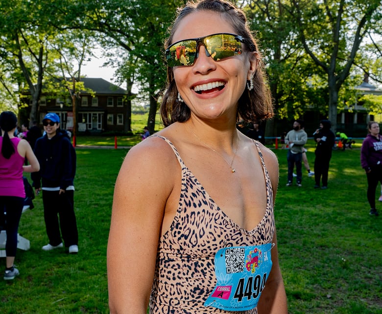 Runner smiling in the sun while wearing mirrored Zunnies sunglasses at a 5K event.
