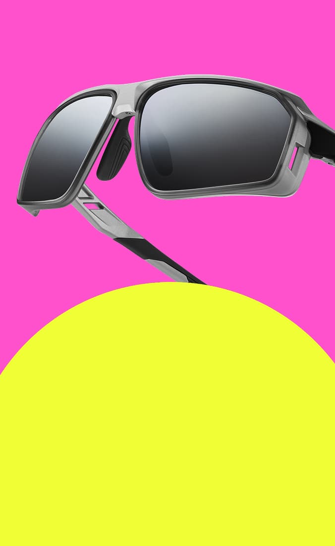 Zunnies sports sunglasses with classic tinted lenses against a pink and yellow background.