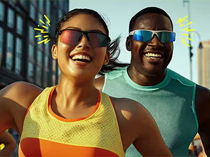 Two athletes smiling and running in a city environment while wearing Zunnies bounce and slip free running sunglasses.