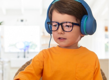 Image of a toddler wearing zenni glasses and headphones.