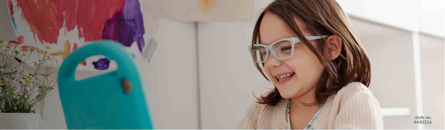 child wearing light blue flexible glasses looking at tablet