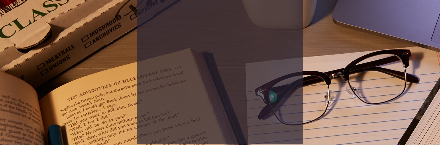 Classic browline glasses #194815 in brown on top of a notepad surrounded by books and a coffee mug. 