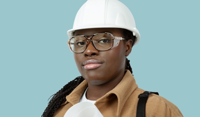 A black woman wearing tortoiseshell Zenni safety glasses and a white hard hat.