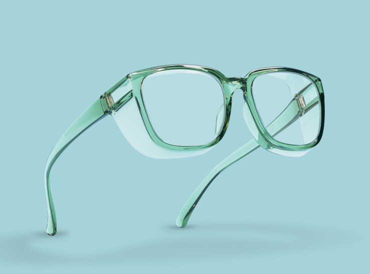 Light green transparent frame protective glasses on a light blue background.