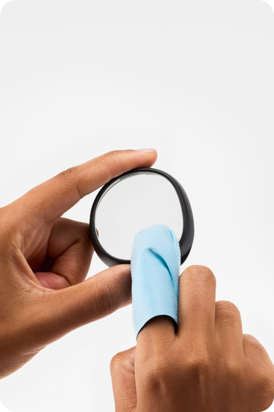 Close-up of hands with a blue lens cloth cleaning a Zenni VR lens insert.