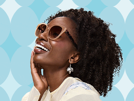 Three smiling people wearing trendy glasses pose in front of a blue patterned background — one with pink round sunglasses and white hair bows, another in dark square frames, and a third in oversized beige sunglasses with curly hair.