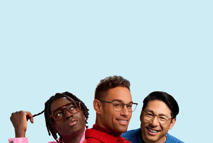Group portrait of three men wearing prescription eyeglasses against a light blue background, featuring a man with dreadlocks looking up in translucent brown aviator frames, a smiling man in a red jacket wearing grey rectangular metal frames, and a smiling man in a blue sweater wearing thin gold wire aviator frames.